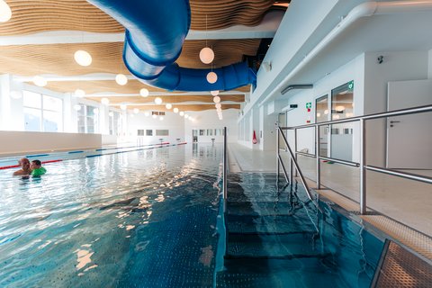 Hallenbad im Aua Grava wellnessHostel 3000 in Laax. Obehalb des 25-Meter Beckens schlängelt sich die Rutsche entlang. 