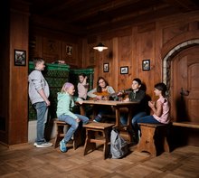 Eine Gruppe Schüler*innen sitzen mit ihrer Lehrerin in der Jugendherberge Brugg und singen. Die Lehrerin spielt Gitarre
