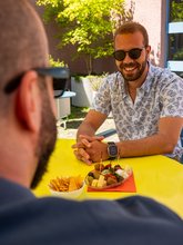 Zwei Gäste sitzen im Hof der Jugendherberge Zürich und geniessen Tappas.