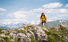 Frau mit gelbem T-Shirt auf einer Wanderung in der Region Gstaad Saanenland.