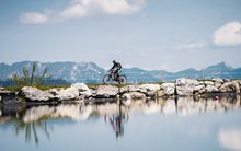 Sina Candrian fährt in der Nähe am See das Velo. 