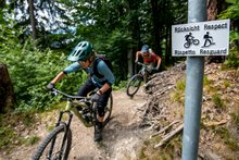 Velofahrer mit einem Warnschild "Rücksicht". 