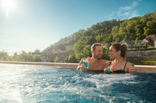 A couple enjoys the outdoor pool at the FORTYSEVEN wellness spa in Baden.