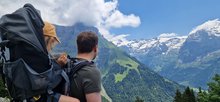 Father and child in a backpack on a hike in Engelberg.